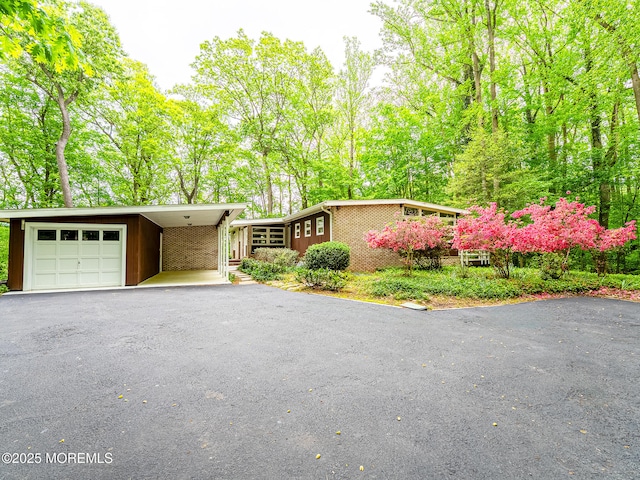 view of front of house with asphalt driveway, a carport, and brick siding