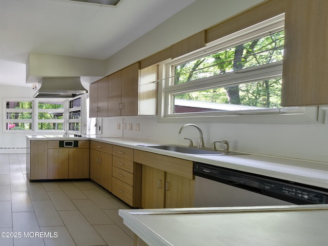 kitchen with a sink, stainless steel dishwasher, light countertops, a peninsula, and light tile patterned floors