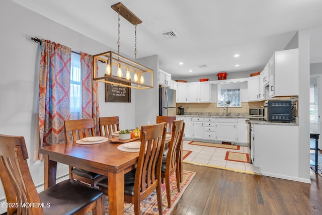 dining space featuring sink, plenty of natural light, and light hardwood / wood-style flooring