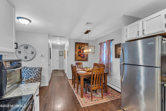 dining room with dark hardwood / wood-style flooring and a baseboard heating unit