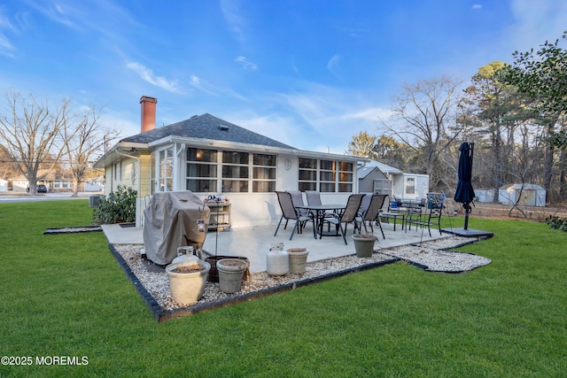 back of house with a patio, a lawn, and a sunroom