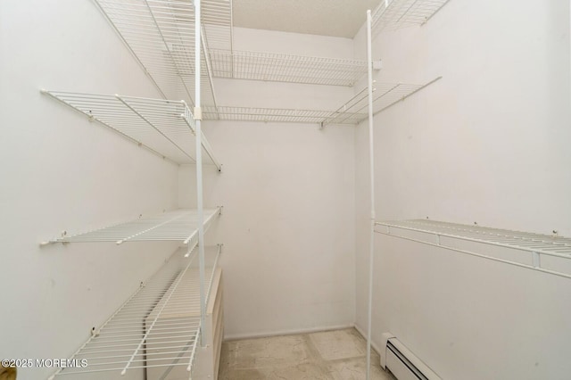 walk in closet with a baseboard heating unit