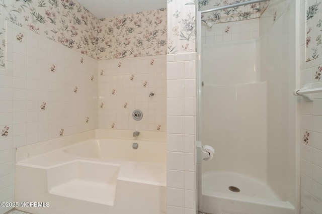 bathroom with a wainscoted wall, a garden tub, tile walls, a stall shower, and wallpapered walls