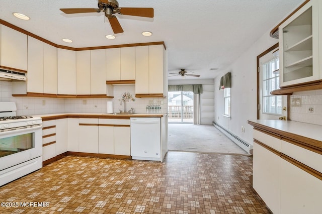 kitchen featuring white appliances, a sink, white cabinets, light countertops, and baseboard heating