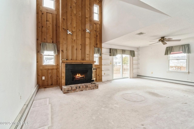 unfurnished living room featuring carpet floors, a baseboard radiator, a fireplace, and visible vents