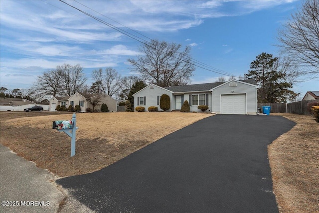 ranch-style home featuring driveway, a garage, a residential view, and fence