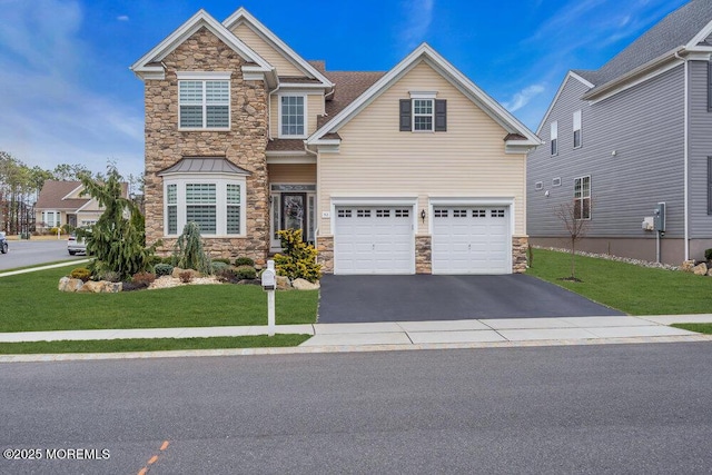 craftsman house with aphalt driveway, stone siding, an attached garage, and a front yard