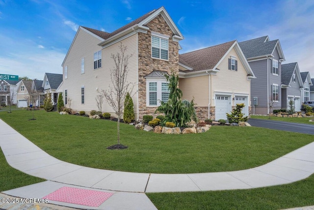 view of front facade featuring aphalt driveway, stone siding, a front lawn, and a garage