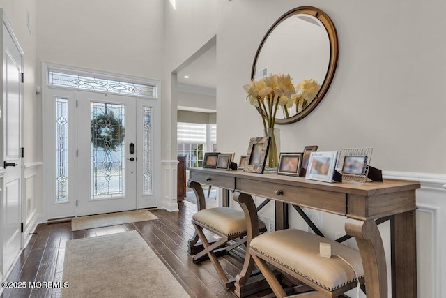 entrance foyer featuring dark wood-style flooring and a towering ceiling