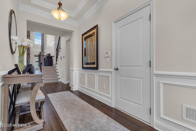 corridor featuring a wainscoted wall, stairway, visible vents, and dark wood-style flooring