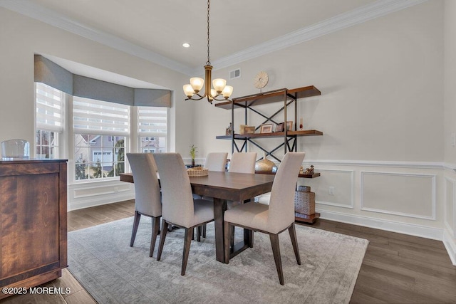 dining space featuring a notable chandelier, wood finished floors, and visible vents