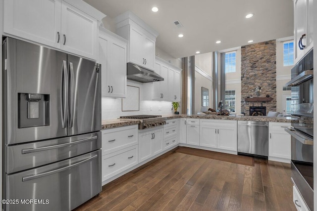 kitchen with visible vents, under cabinet range hood, tasteful backsplash, white cabinetry, and appliances with stainless steel finishes