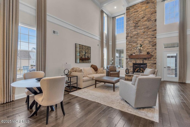 living area with visible vents, plenty of natural light, and dark wood-style flooring