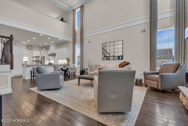 living area featuring visible vents, dark wood-style floors, recessed lighting, a high ceiling, and baseboards