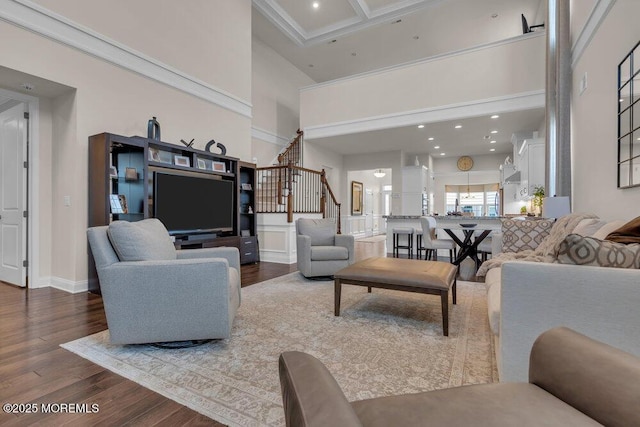 living room featuring baseboards, stairs, recessed lighting, a towering ceiling, and wood finished floors