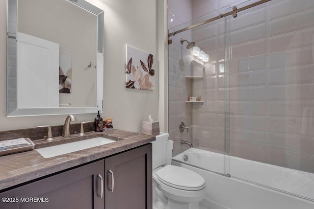 bathroom with bath / shower combo with glass door, toilet, and vanity