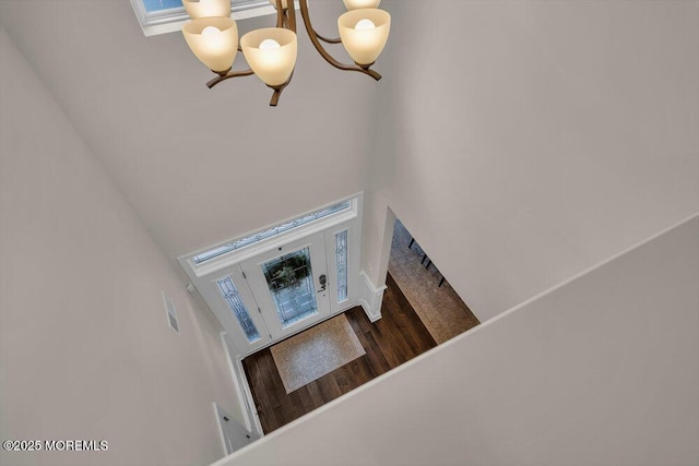 stairs featuring wood finished floors and a towering ceiling