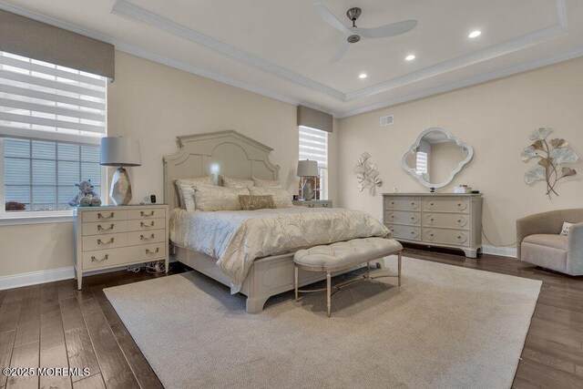 bedroom with a tray ceiling, dark wood-style floors, and ornamental molding