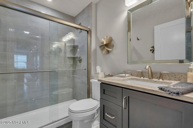 full bathroom with a stall shower, toilet, and vanity