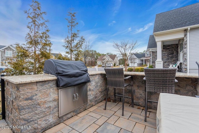 view of patio with grilling area, an outdoor kitchen, and outdoor dry bar