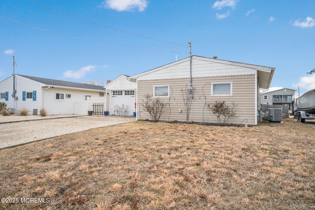 rear view of property featuring cooling unit and a yard