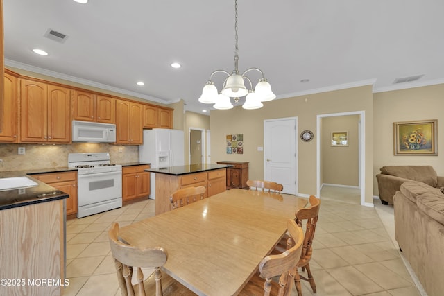 kitchen with white appliances, hanging light fixtures, a center island, light tile patterned flooring, and decorative backsplash