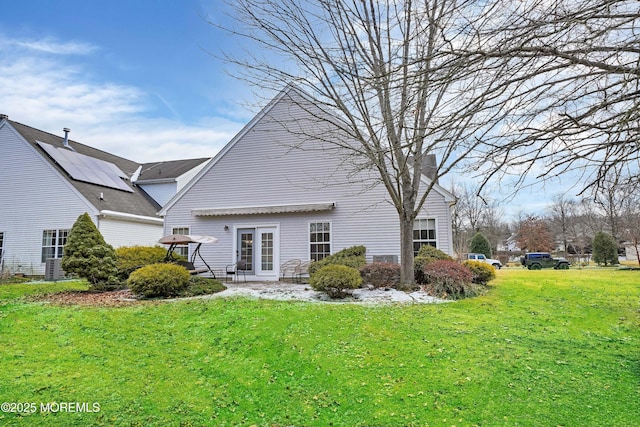 back of property with central AC unit and a lawn