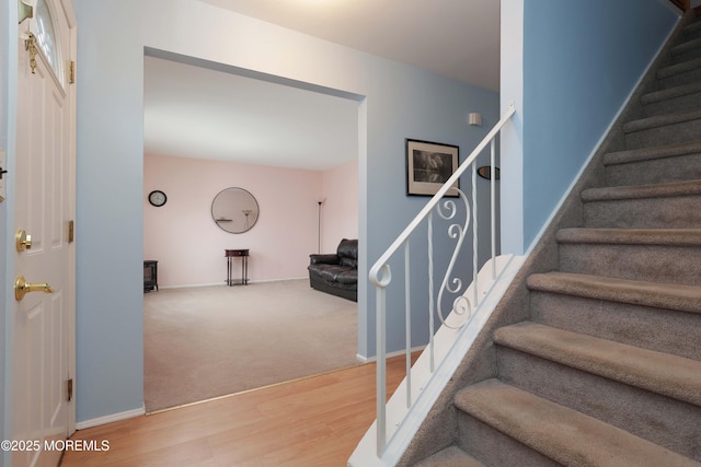 staircase featuring hardwood / wood-style floors and a wood stove