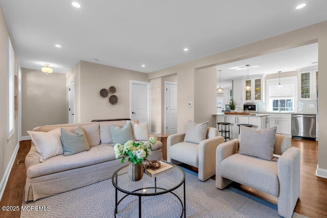 living area featuring recessed lighting, baseboards, and wood finished floors