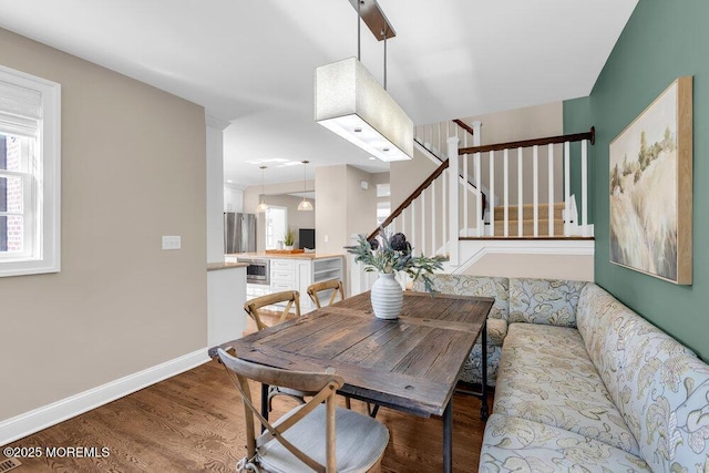 dining room featuring stairway, baseboards, and wood finished floors