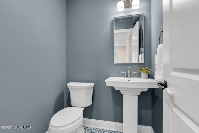 bathroom with toilet and baseboards