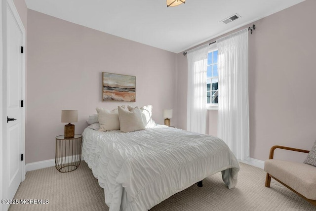 bedroom with light carpet, visible vents, and baseboards