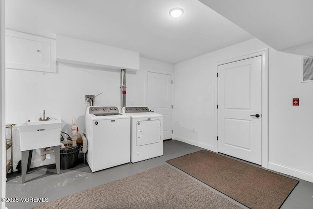 clothes washing area featuring washer and dryer, laundry area, and baseboards