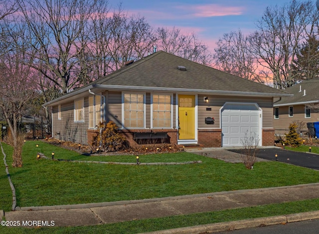 single story home with a garage and a lawn