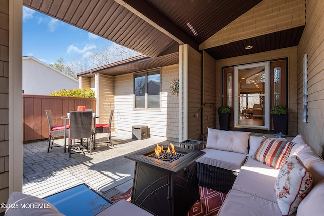 view of patio featuring an outdoor living space with a fire pit, outdoor dining space, and fence