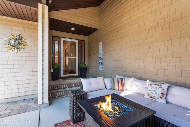 view of patio with an outdoor living space with a fire pit