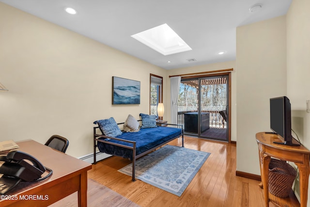 home office with light wood-style flooring, recessed lighting, a skylight, baseboards, and baseboard heating