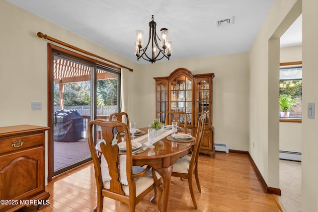 dining room featuring light wood finished floors, a chandelier, baseboards, and a baseboard radiator