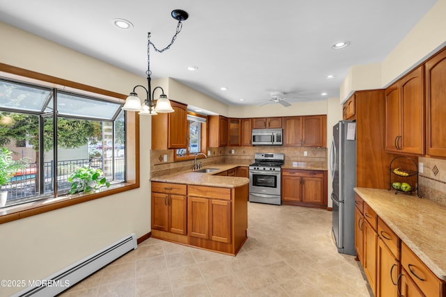 kitchen with pendant lighting, baseboard heating, brown cabinets, stainless steel appliances, and a sink