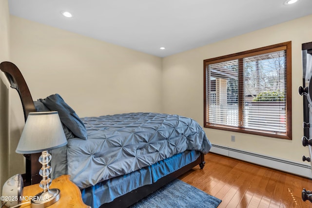 bedroom featuring recessed lighting, wood-type flooring, and baseboard heating