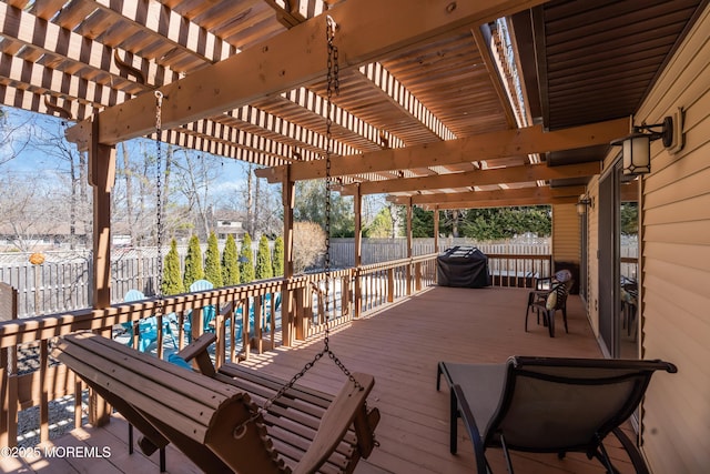 wooden terrace featuring area for grilling, fence, and a pergola