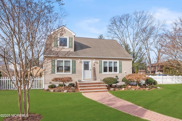 cape cod home with roof with shingles, fence, and a front lawn