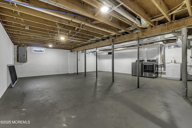 basement featuring electric panel and washer and clothes dryer