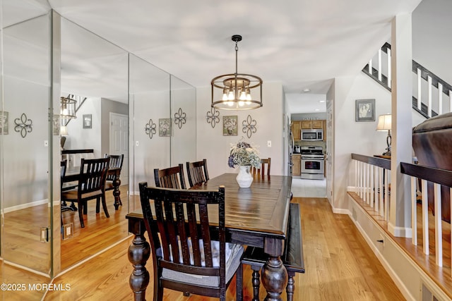 dining space featuring an inviting chandelier and light hardwood / wood-style flooring