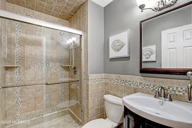 bathroom with vanity, toilet, tile walls, and a shower with shower door