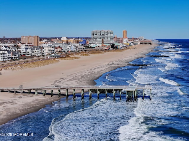 aerial view with a water view and a beach view