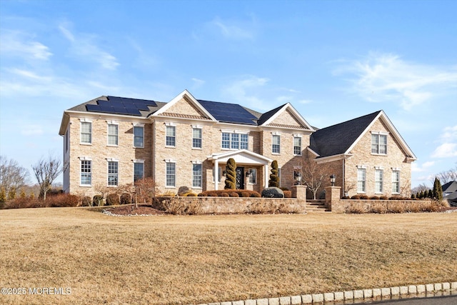 view of front facade featuring solar panels and a front yard