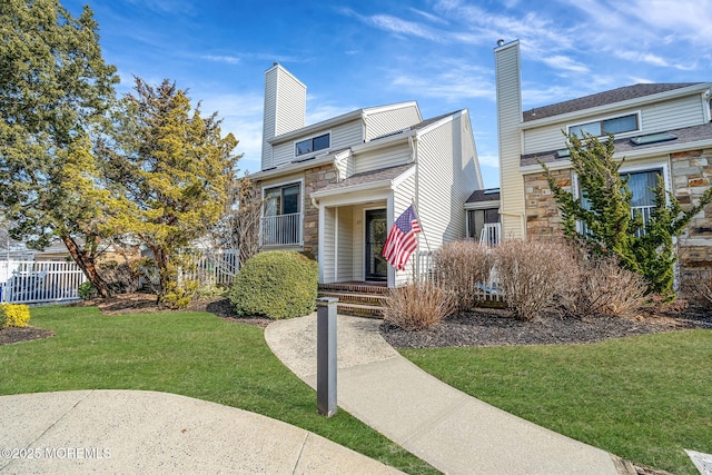 view of front of home featuring a front yard, fence, and a chimney