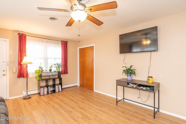 interior space featuring ceiling fan, a baseboard radiator, and light hardwood / wood-style flooring