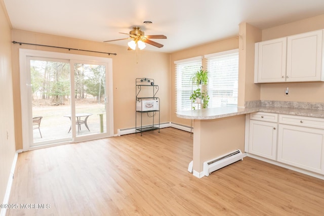 kitchen with white cabinetry, a baseboard heating unit, light wood-type flooring, and kitchen peninsula